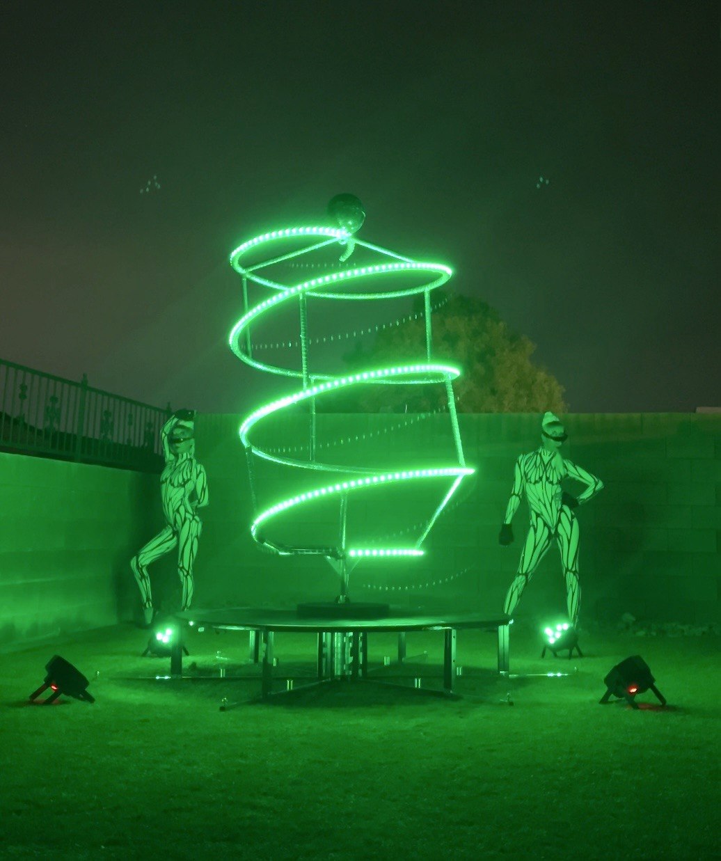 Aerial and ground spiral prop with green LED helix and performers