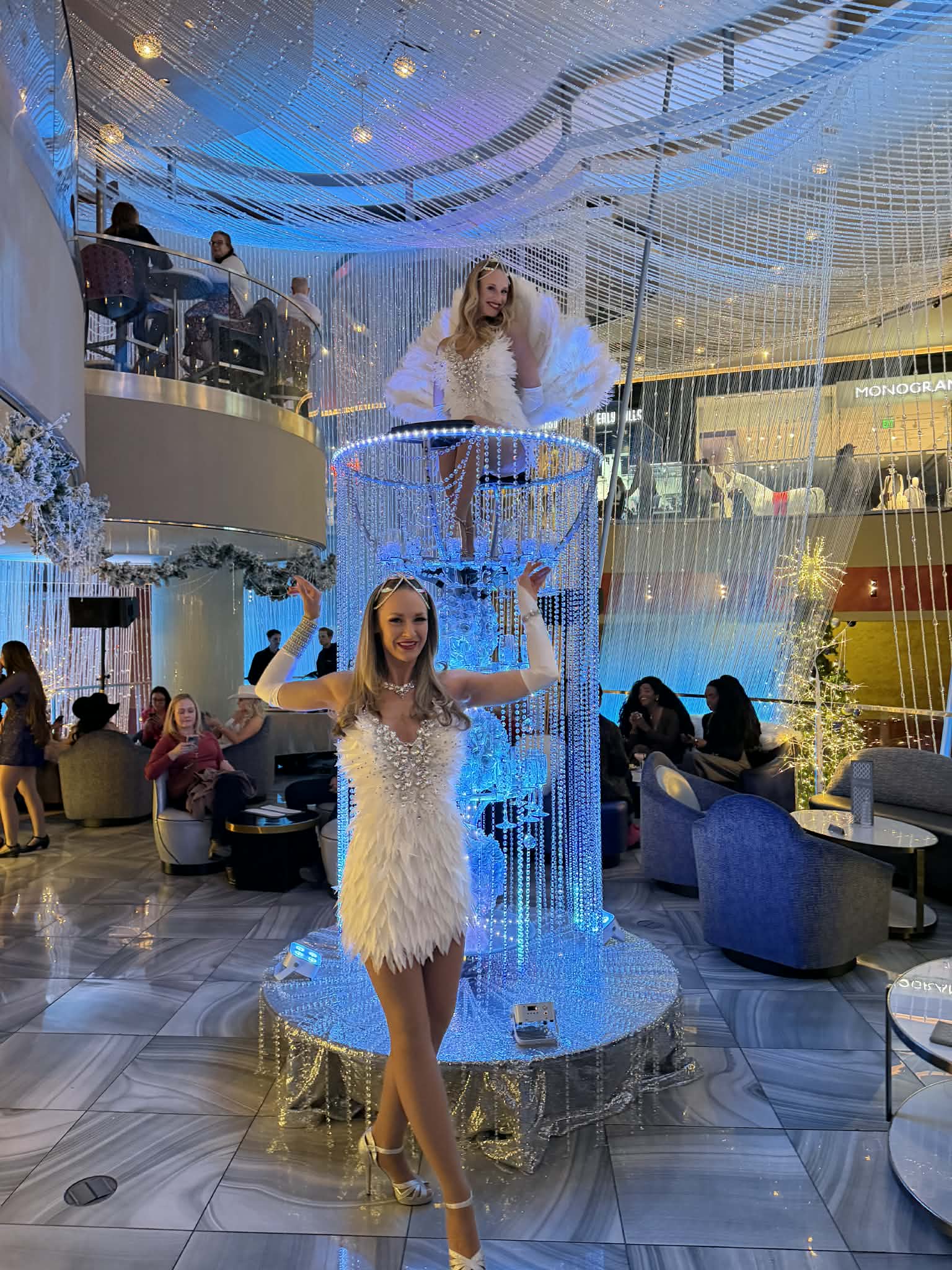 Feather-dressed hostesses at the crystal server tower