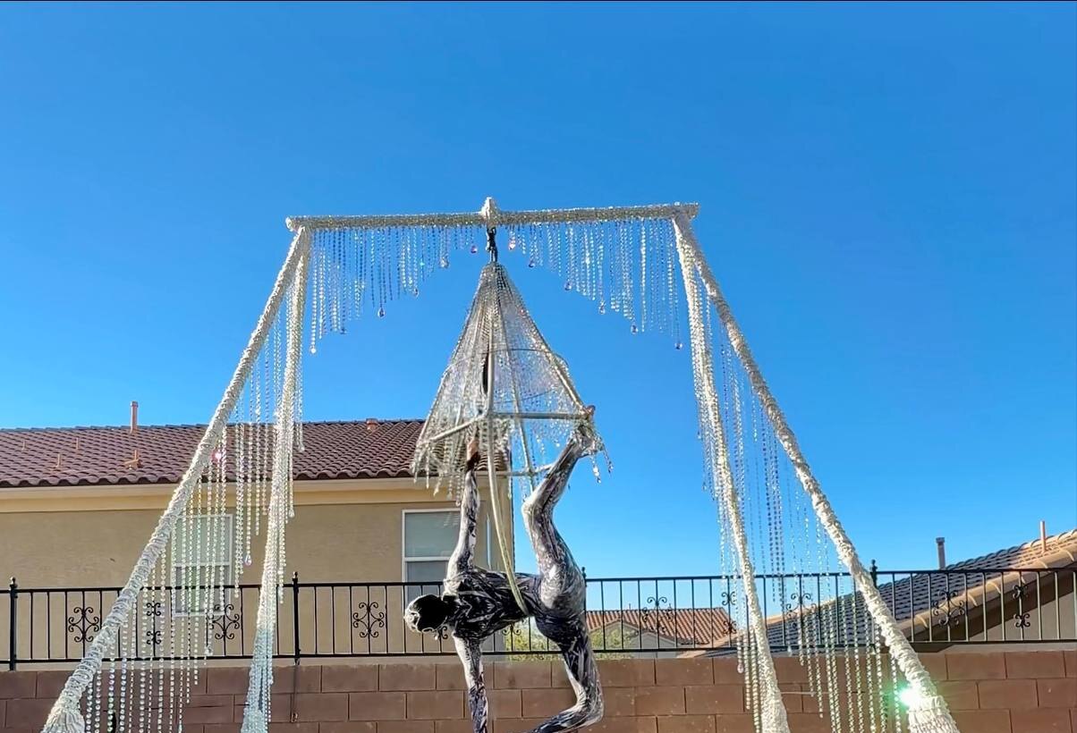 Crystal-draped aerial rig with chandelier and hoop outdoors