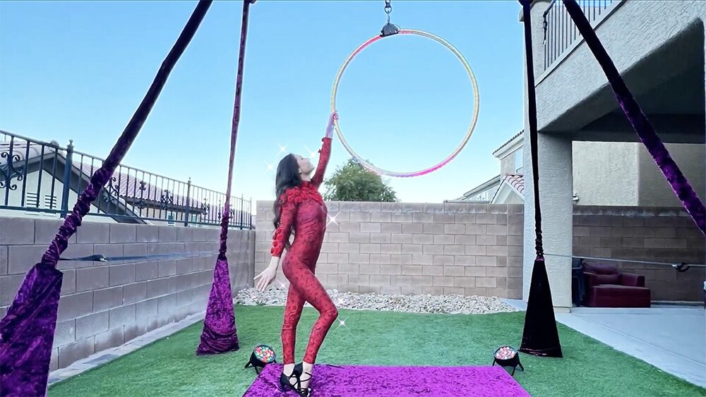 Red-dressed performer at the hoop on the velvet rig