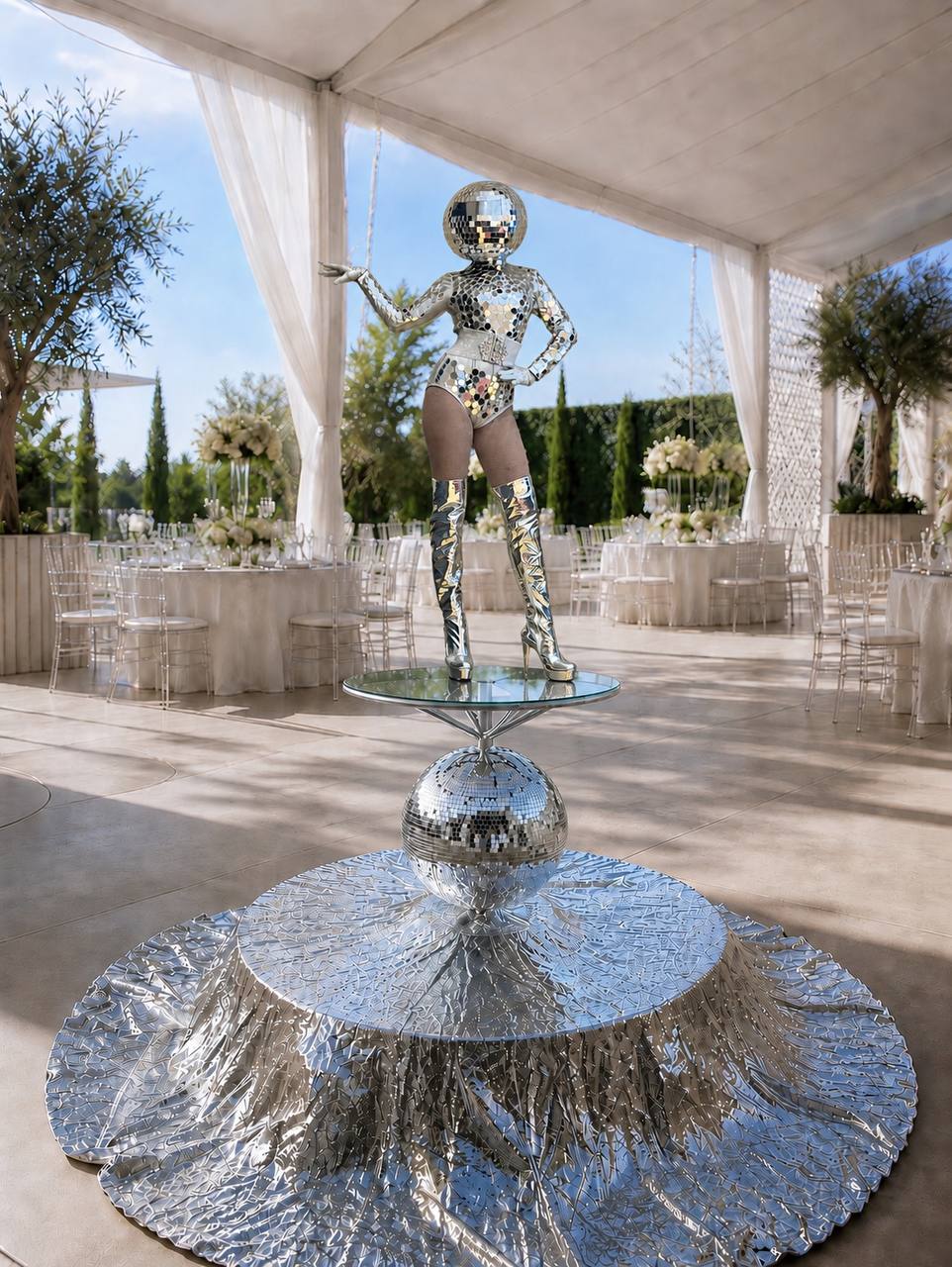 Silver mirror-ball performer on the Disco Luxe Platform in a white Las Vegas event tent