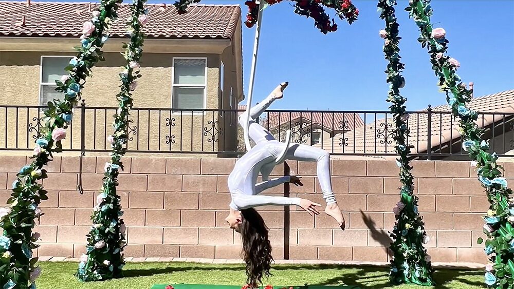 White silks pose on the floral A-frame rig