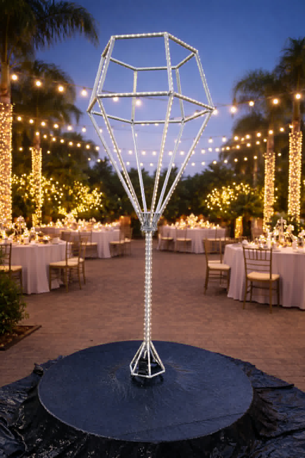 Tall LED diamond prop at a garden reception under string lights